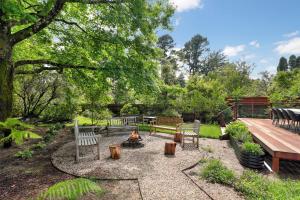 a fire pit in a garden with benches and a picnic table at Finchley in Blackheath