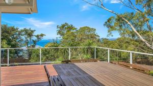a wooden deck with a view of the ocean at 'Spacious Family Retreat' by HolidayCo in Killcare