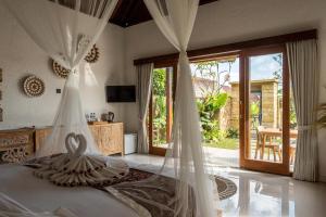a bedroom with a bed with mosquito nets at Sawah Sebatu Villa in Ubud