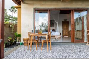 a table and chairs on a patio with a bedroom at Sawah Sebatu Villa in Ubud