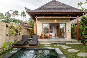 a villa with a pool in front of a house at Sawah Sebatu Villa in Ubud
