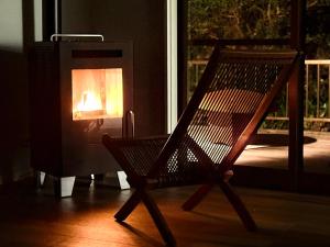 a wooden chair sitting in front of a fireplace at Villa MAEUMー熱海絶景の棟貸しヴィラ BBQとペレットストーブ体験 最大13名追加料金なし in Atami