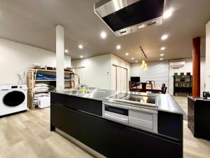 a large kitchen with a sink and a stove at Villa MAEUMー熱海絶景の棟貸しヴィラ BBQとペレットストーブ体験 最大13名追加料金なし in Atami