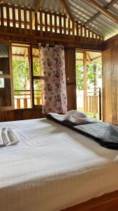 a large white bed in a room with windows at Finca hotel VillaLuna in Mesetas