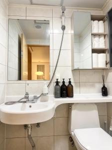 a bathroom with a sink and a mirror and a toilet at Modern 203 Stay in Seoul