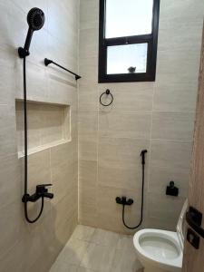 a bathroom with a shower and a toilet and a window at شقة بغرفة معيشة وغرفة نوم in Buraydah