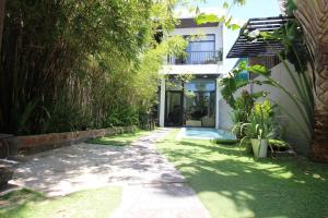 a walkway leading to a house with plants at Tehya Villa in Da Nang