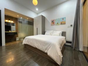 a bedroom with a large white bed and a bathroom at Tehya Villa in Da Nang +24 photos