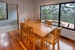 a dining room with a wooden table and chairs at Delmonte in Medlow Bath +6 photos