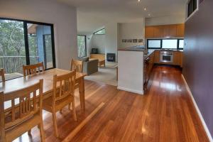 a kitchen and living room with a wooden table and chairs at Delmonte in Medlow Bath