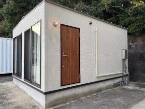 a small building with a wooden door on it at Yura terrace in Yura