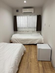 a bedroom with two beds and a window at Yura terrace in Yura