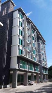 a tall building with a car parked in front of it at The new concept office plus in Ban Fon