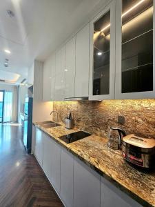 Căn hộ homestay Doji Diamond Crown في هاي فونج: مطبخ بخزائن بيضاء وطاولة عمل +12 صورة