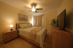 Un dormitorio con una cama y un ventilador de techo. en E&A SouthWest Miami - Breeze Studio, en Lindgren