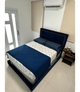 圣胡安Kantares Guest a 4 min Aeropuerto的卧室内的一张床铺,配有蓝色棉被