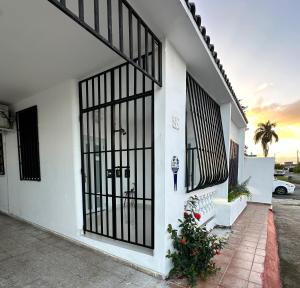 圣胡安Kantares Guest a 4 min Aeropuerto的一栋白色建筑，门上有黑色大门。