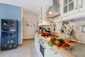 eine Küche mit weißen Schränken und Obst und Gemüse auf der Theke in der Unterkunft Blu Oltrelago Pool & Lake - Happy Rentals in Leggiuno