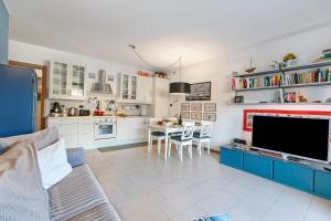 ein Wohnzimmer mit einem großen TV und einem Tisch in der Unterkunft Blu Oltrelago Pool & Lake - Happy Rentals in Leggiuno