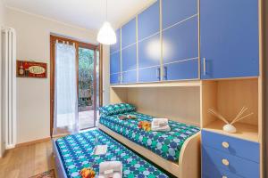 ein Kinderzimmer mit blauen Schränken und einem Bett in der Unterkunft Blu Oltrelago Pool & Lake - Happy Rentals in Leggiuno