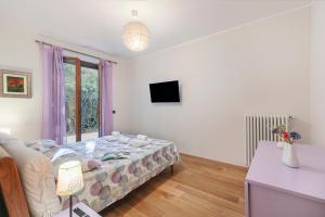 ein Schlafzimmer mit einem Bett und einem Fernseher darin in der Unterkunft Blu Oltrelago Pool & Lake - Happy Rentals in Leggiuno