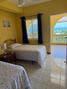 a hotel room with two beds and a window at Superstar Living in Treasure Beach