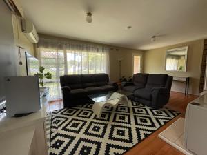 Canberra Hospital Locum Welcome Entire Family Home في Phillip: غرفة معيشة بها أريكة وطاولة