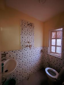 a bathroom with a toilet and a sink and a window at Hotel Pokhara Peace in Kathmandu