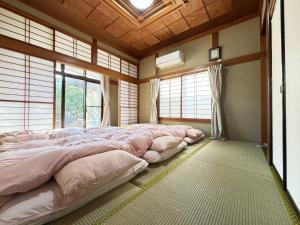 a bedroom with a large bed in a room with windows at 一棟貸しの宿 貸別荘 水戸ハウス Vacation Rental Mito House! Location is 1-2-55 Kanemachi Ibaraki Prefecture 場所は茨城県水戸市金町1-2-55です ドア横のキーボックスの番号はご予約後に,チェックイン情報を見る,をご覧下さい in Mito