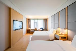 ein Hotelzimmer mit zwei Betten und einem Fernseher in der Unterkunft JI Hotel Shanghai Wujiaochang Wanda Plaza in Shanghai + 47 Fotos