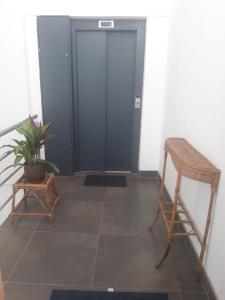 a room with a door and a chair and a plant at Corta Estadía Sucre in Sucre