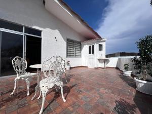 a patio with two chairs and a table on a house at Corta Estadía Sucre in Sucre