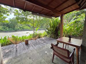a patio with a table and chairs on a deck at Balian River Hut in Balian