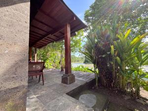 a pavilion with a bench sitting on a patio at Balian River Hut in Balian