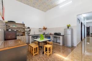 a kitchen with a table and some stools in it at Hà Giang Homestay - Nhà phố Du lịch Biển Vũng Tàu Gần bãi biển Long cung in Vung Tau