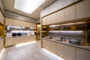 eine große Küche mit vielen Arbeitsflächen und Regalen in der Unterkunft JI Hotel Shanghai Wujiaochang Wanda Plaza in Shanghai