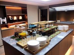 Super 8 Hotel Xian Nanshaomen في شيان: طابور بوفيه مع الأطباق وأصناف الطعام الأخرى