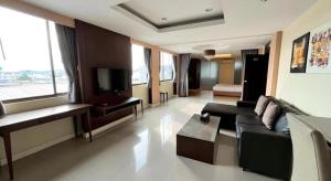 a living room with a couch and a television at Laemchabang City Hotel in Ban Thung Sukla