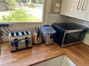 Canberra Hospital Locum Welcome Entire Family Home في Phillip: طاولة مطبخ مع ميكروويف ومحمصة +13 صورة