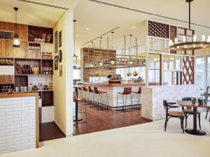 a kitchen with a bar and some tables and chairs at Pullman Dubai Jumeirah Lakes Towers in Dubai