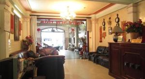 a living room with leather furniture and a chandelier at Timi Hotel in Ho Chi Minh City