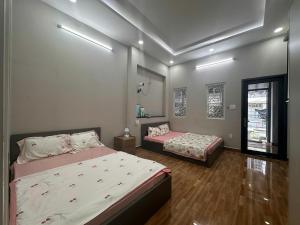 a bedroom with two beds and a window at AP Home in Ho Chi Minh City
