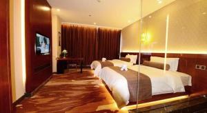 a hotel room with two beds and a television at James Joyce Coffetel Golmud Huaxing Plaza Branch in Golmud +73 photos
