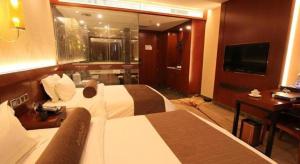 a hotel room with a large bed and a television at James Joyce Coffetel Golmud Huaxing Plaza Branch in Golmud