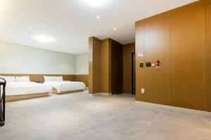 a hotel room with two beds and a door at Noble Hotel in Yeosu