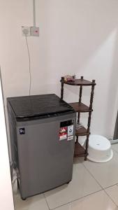 a small refrigerator in a room with a table at Sakeena Homestay in Padang Serai