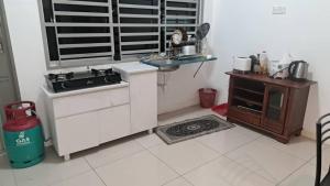 a kitchen with a sink and a stove and a table at Sakeena Homestay in Padang Serai