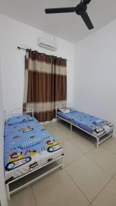 two twin beds in a room with a ceiling at Sakeena Homestay in Padang Serai