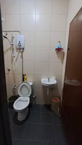 a small bathroom with a toilet and a sink at Sakeena Homestay in Padang Serai +8 photos
