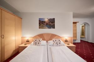 a bedroom with two beds and a painting on the wall at Zimmervermietung Zum Weissen Rössl in Sarntal